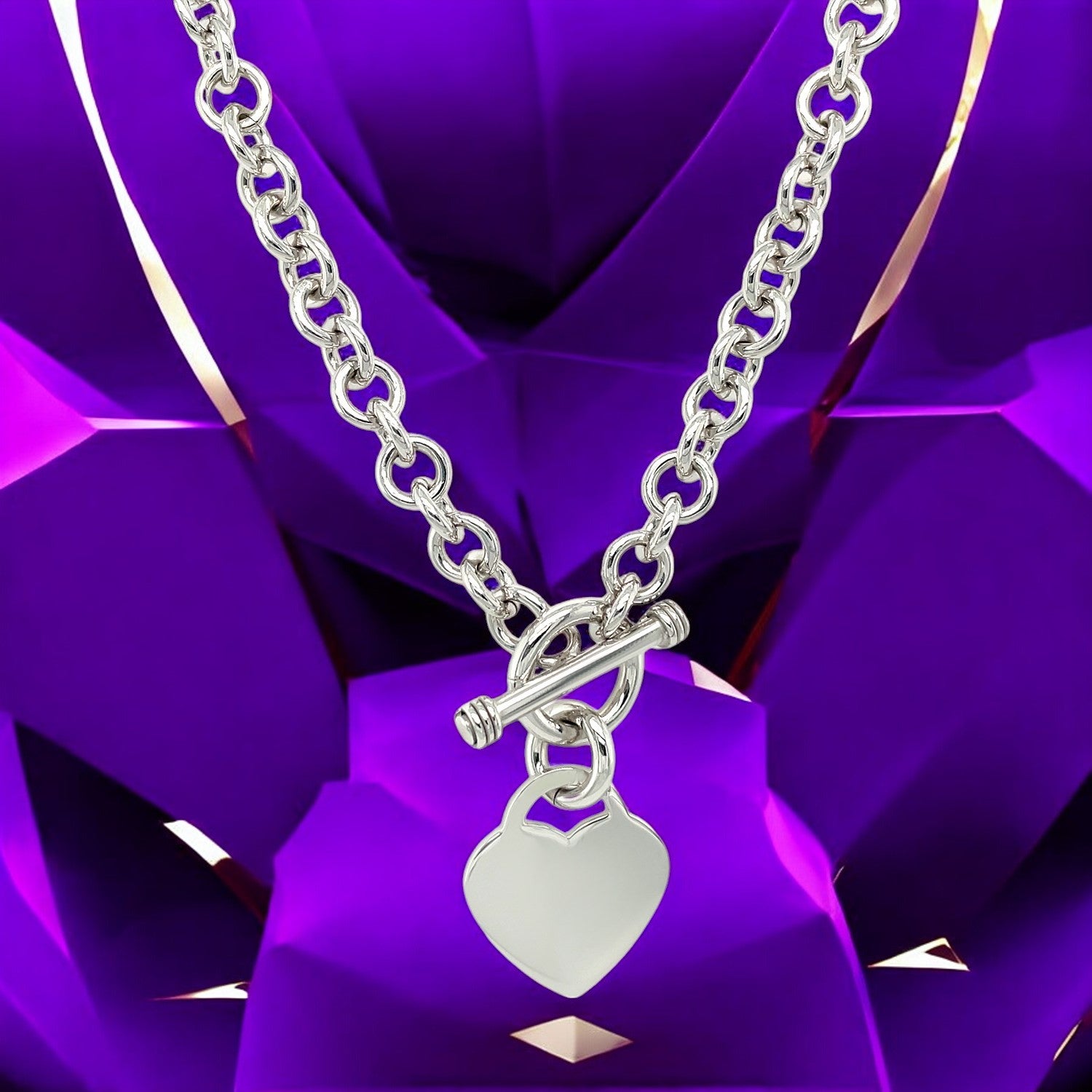 "Stylish silver heart pendant chain necklace with toggle clasp against a purple geometric background."