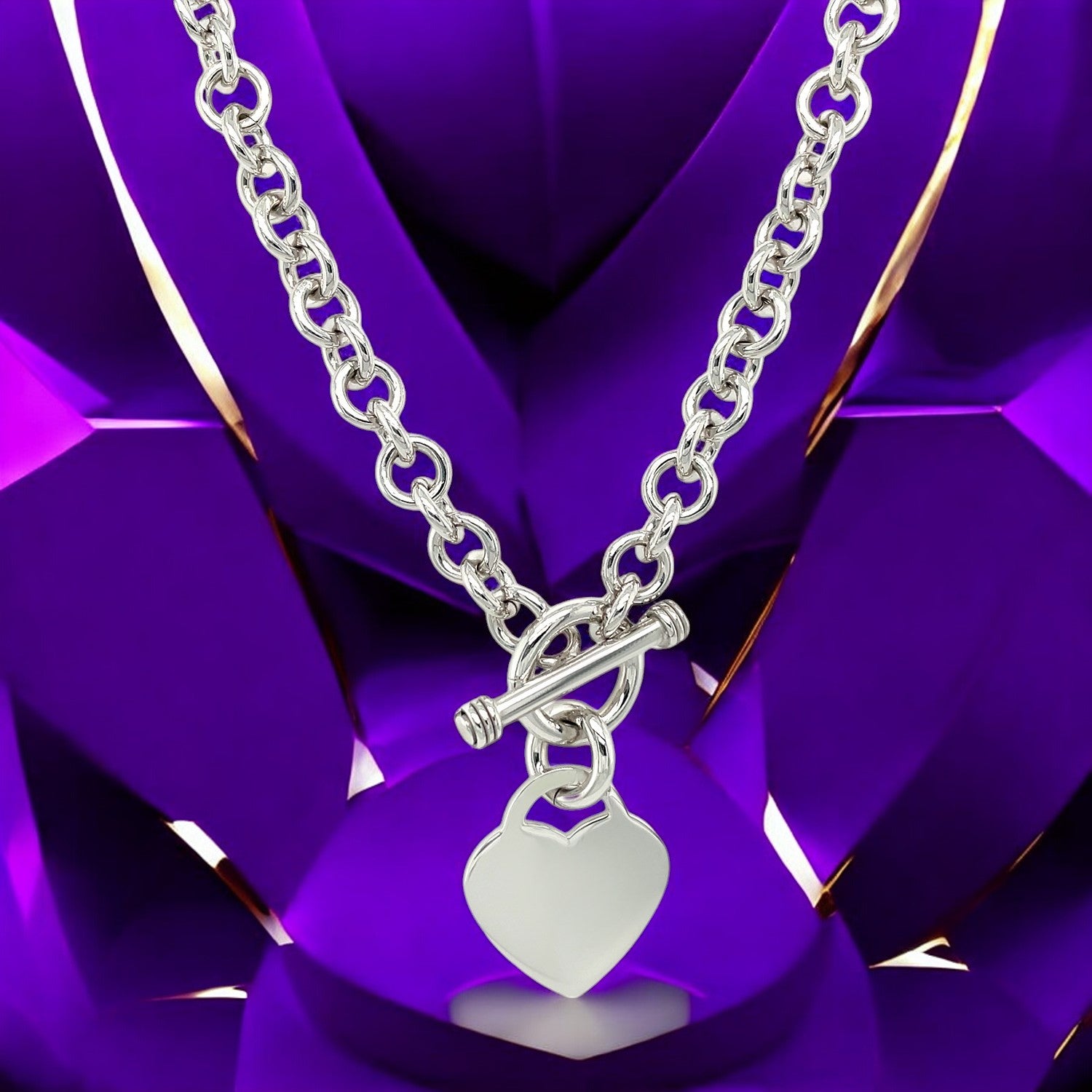 "Stylish silver heart pendant chain necklace with toggle clasp against a purple geometric background."